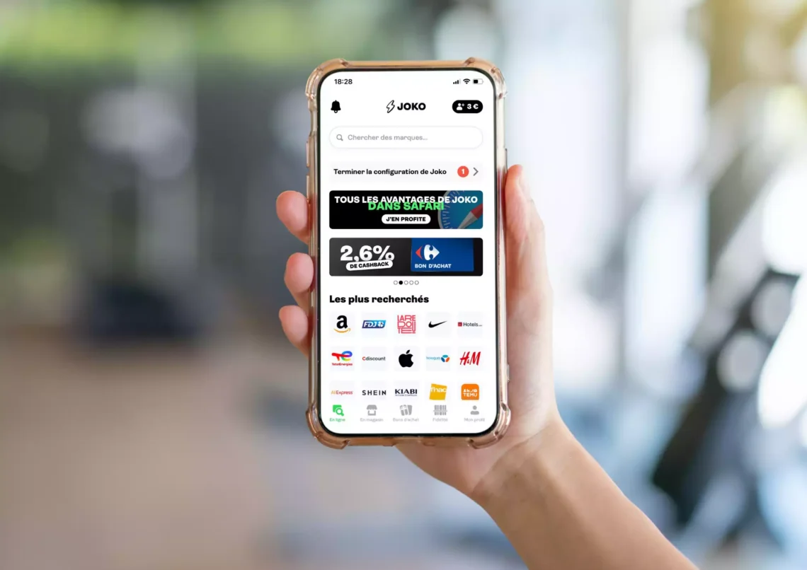 une personne tient en main un téléphone, sur lequel on voit l'application Joko ouverte. Mon avis sur Joko
