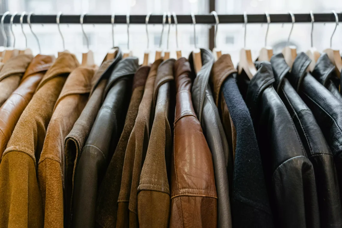 Portant à vêtements avec des vestes en cuir noires et marrons. Entretien du cuir