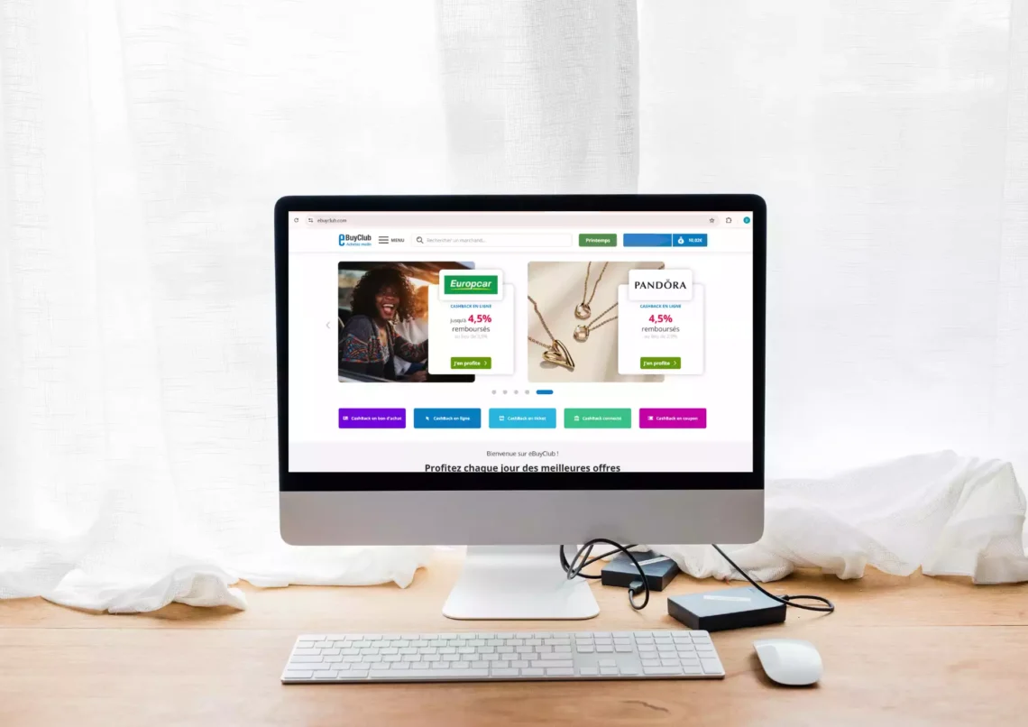 ordinateur sur un bureau dans un décor épuré. il y a une page web ouverte sur le site de cashback eBuyClub. l'article donne un avis sur ebuyclub