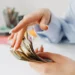 mains de jeune femme en train de jouer avec une liasse de billets en euro