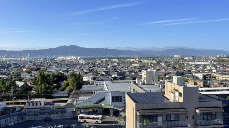 Vue depuis le dernier étage de l'APA Hotel Otsu au Japon, vue sur la gare Seta, le lac Biwa et les montagnes